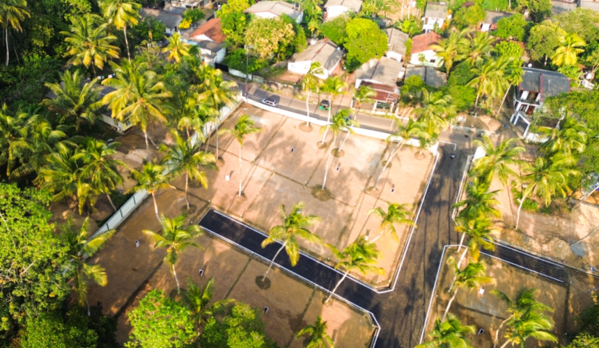 Estate 4 Aerial view of a landscaped residential plot with palm trees and boundary walls