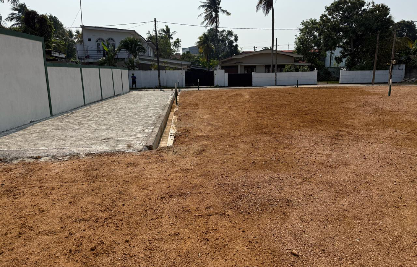 Empty plot with houses visible in the background