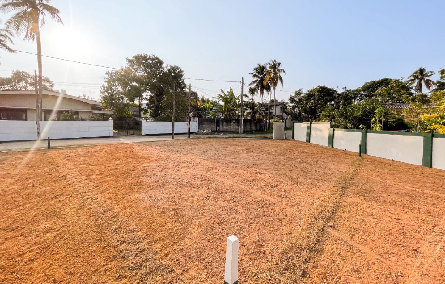 Wide open plot with surrounding compound walls